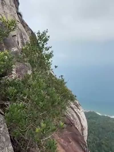 Belayed on a ledge, boots over the void, the coast far below.